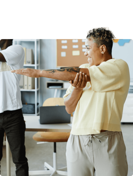 A group of people in an office doing a stretching exercise.