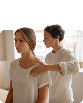 A woman is having her neck adjusted by another woman.