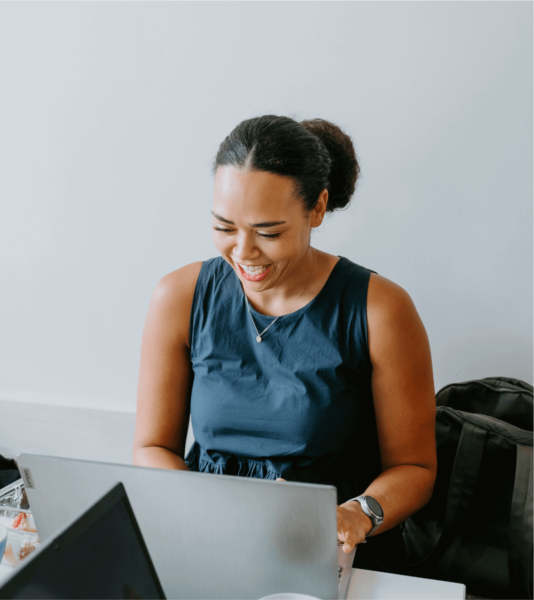 A woman working on a laptop in an office.