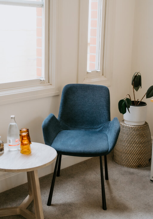 A blue chair sits next to a window in Domain Health clinic