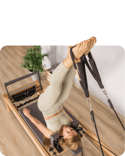 A woman performing Clinical Pilates on a pilates machine.