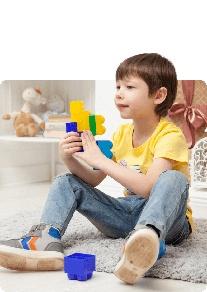 A young boy playing with puzzles in a room.