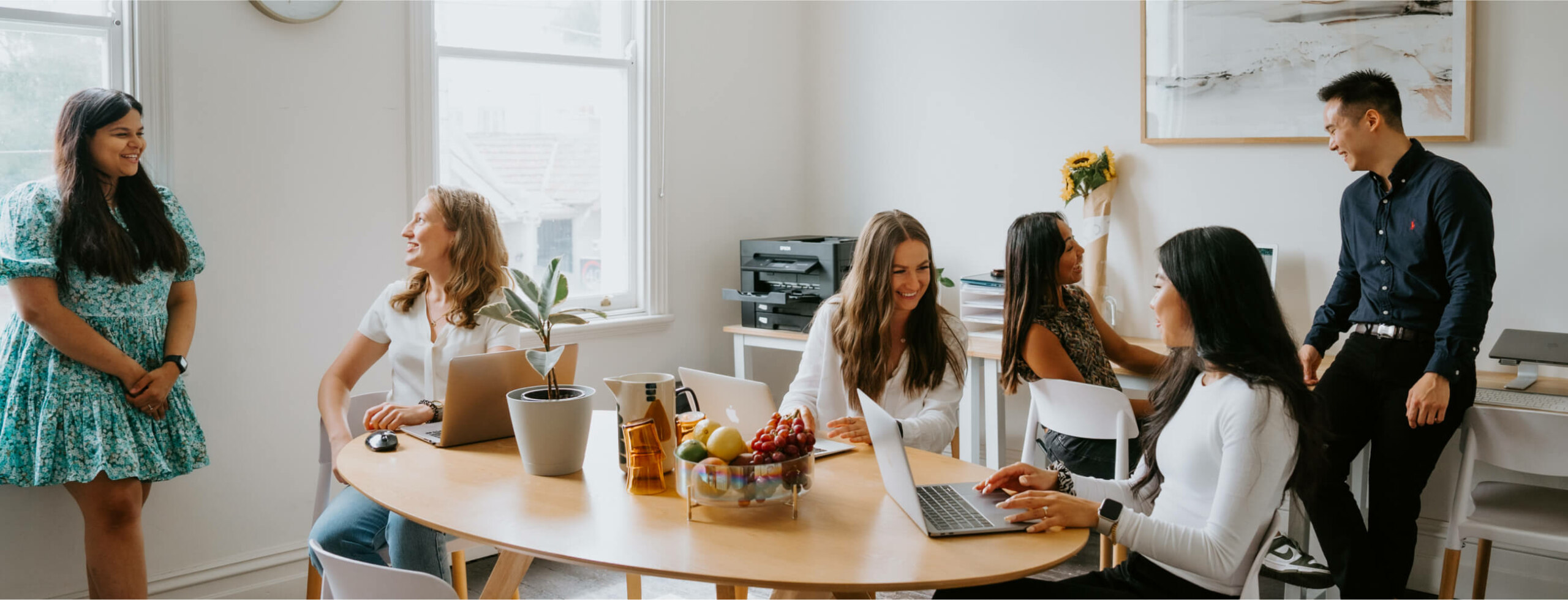 Domain Health team, A group of people sitting around a table in an office.