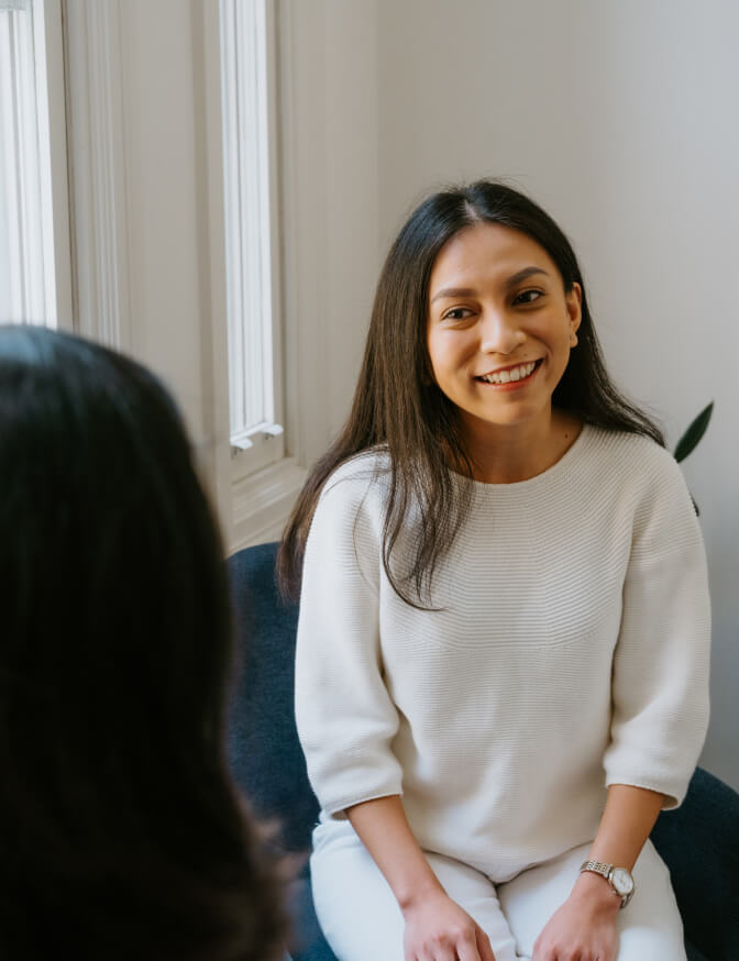 Therapist sitting in a chair and talking to a client
