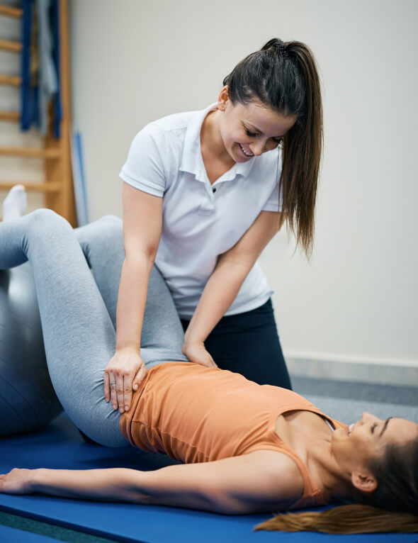 A woman is being helped by a physical therapist