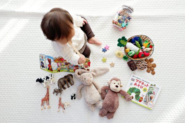 A baby is playing with stuffed animals, developing motor milestones.