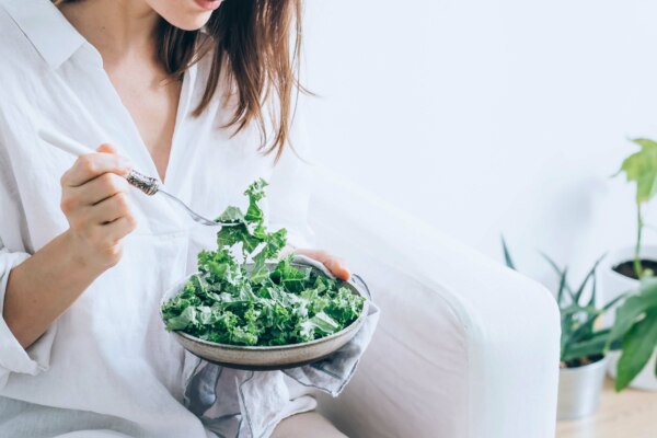 An individual is consuming kale salad.