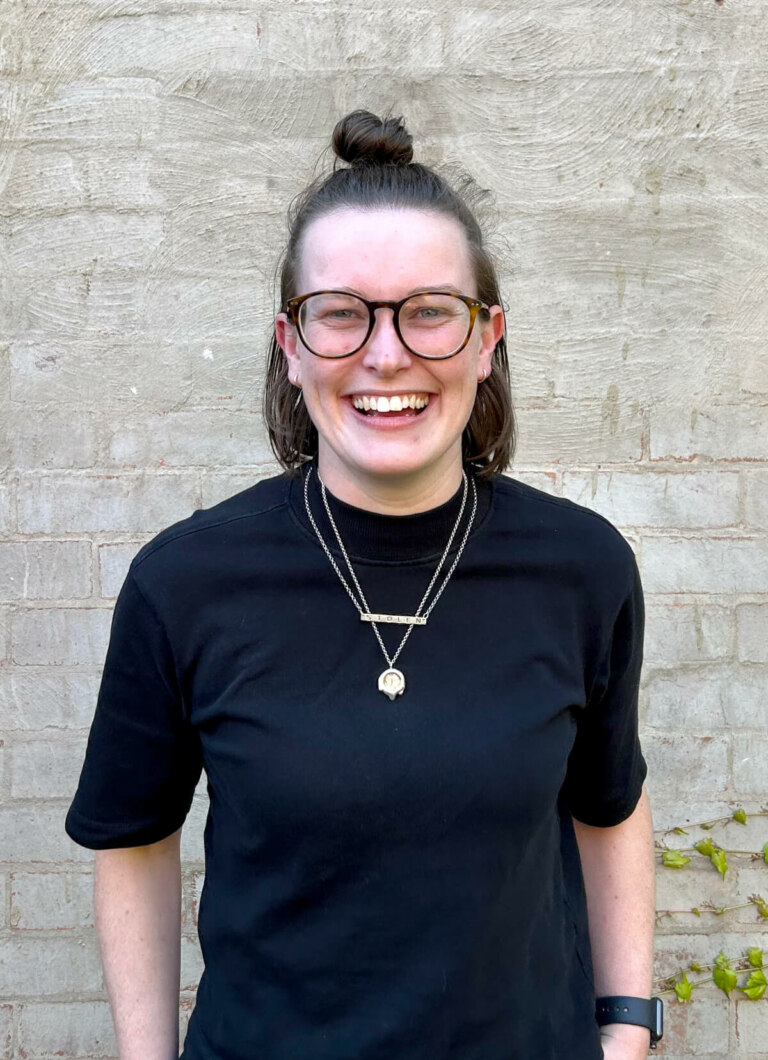 Sophia Cormack, a young woman, wearing glasses and a black t-shirt.